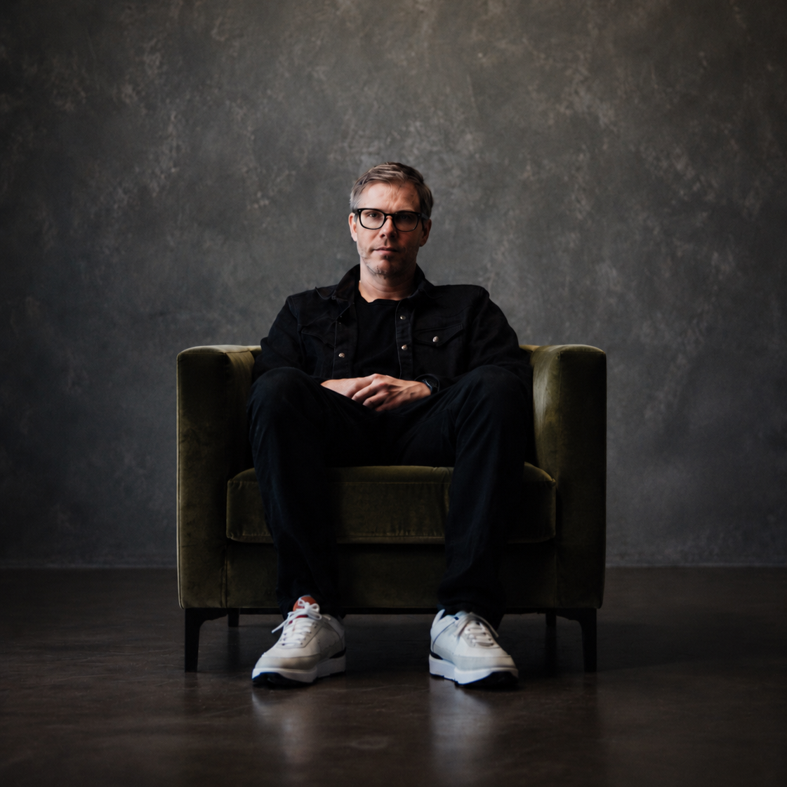 Brian Lee White seated in a studio chair